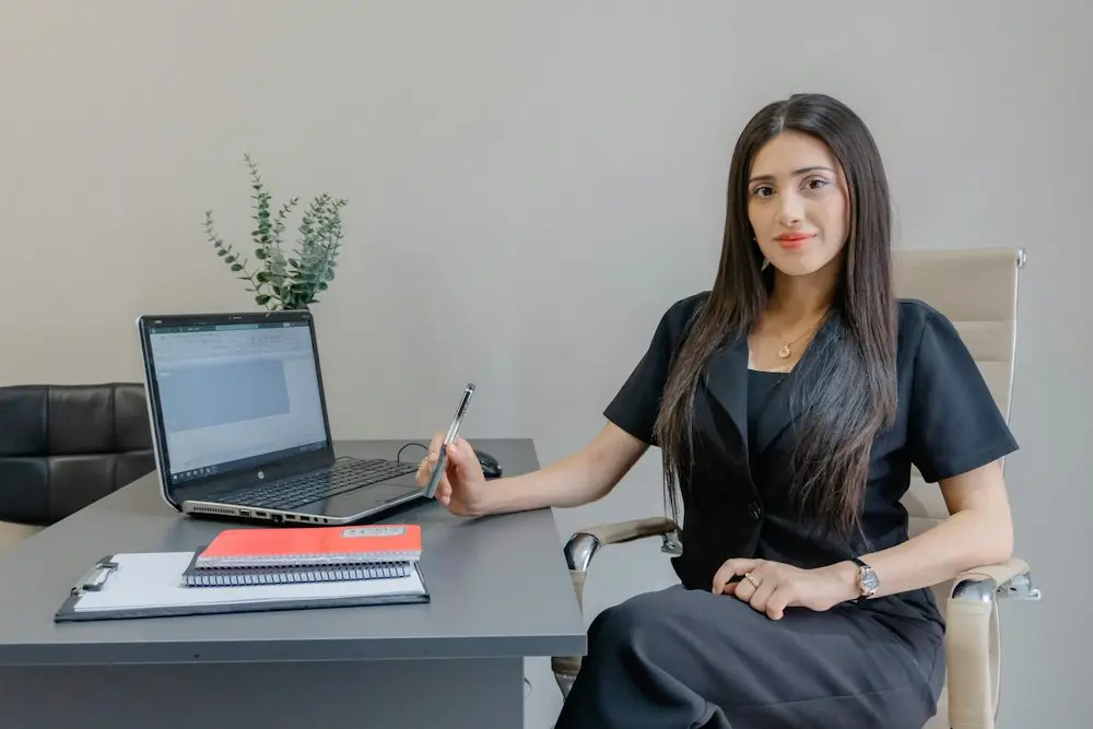 Advisor smiling at her desk with a laptop