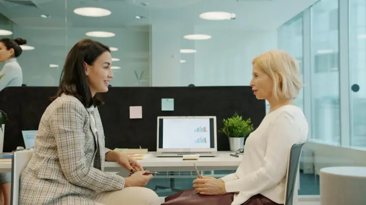 Two women in conversation in a modern office