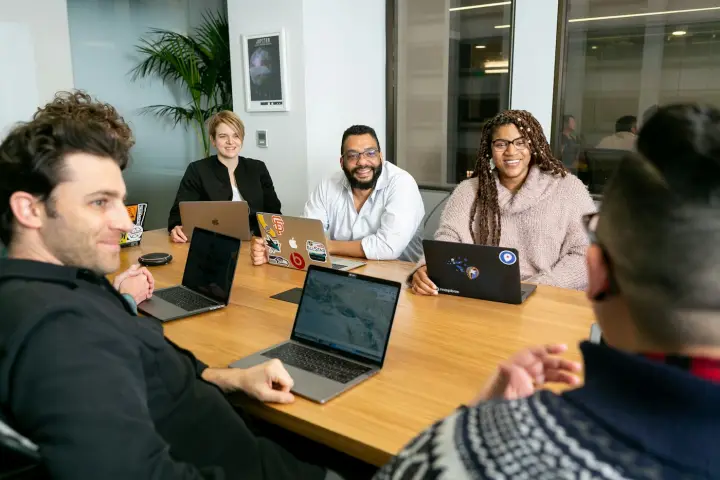 Team on laptops listening in a meeting