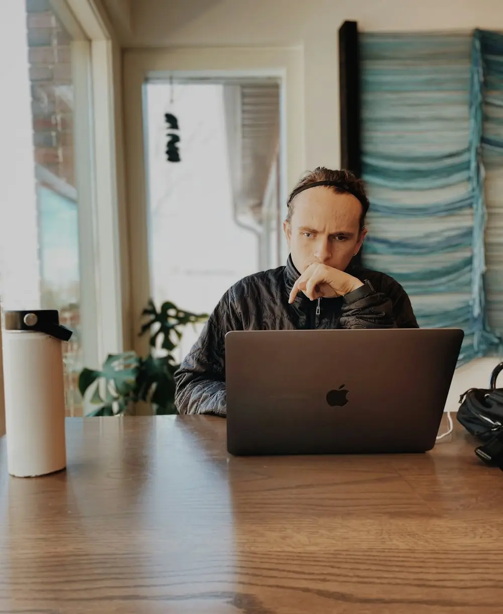 Man thinking in front of a laptop